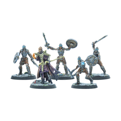 Five skeletal warrior miniatures. A robed sorcerer with an orange orb leads four armored warriors holding swords, shields, and a blue orb