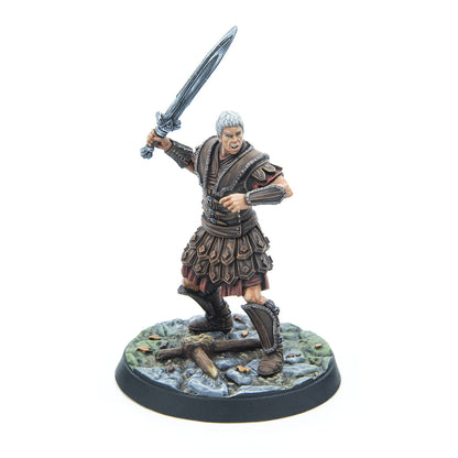 A grey-haired warrior miniature in leather armor fiercely swings a sword, standing on a rocky base
