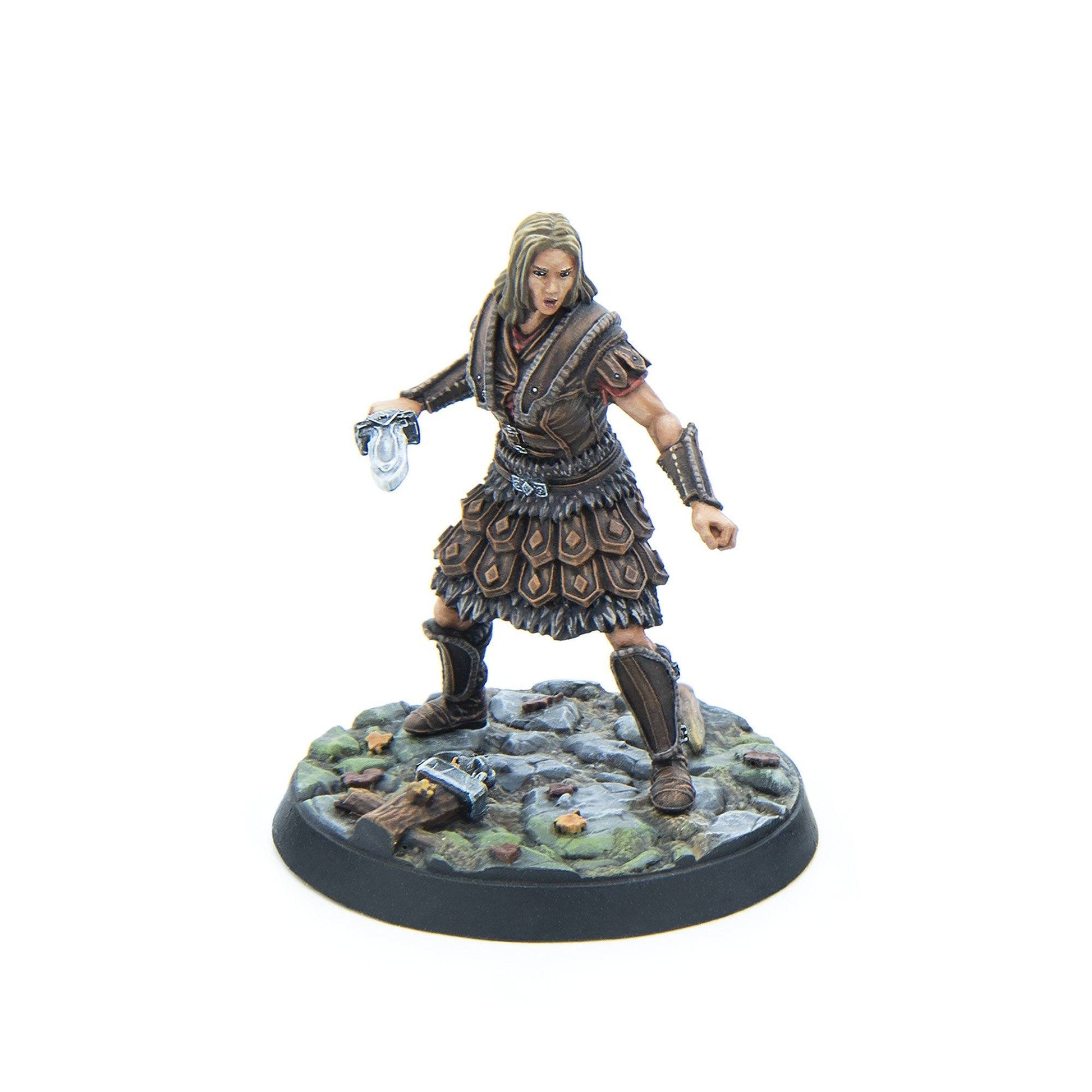 Painted miniature of a blonde female warrior in brown leather armor, holding a dagger, poised on a rocky base