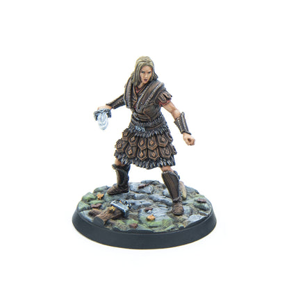 Painted miniature of a blonde female warrior in brown leather armor, holding a dagger, poised on a rocky base