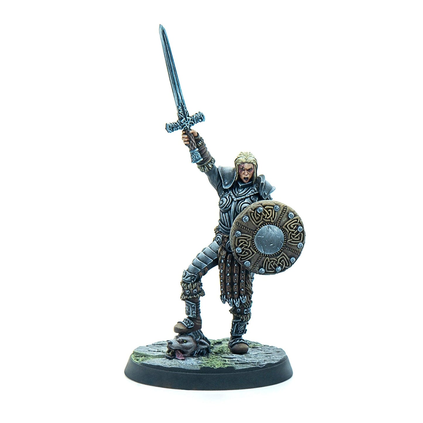Miniature of a blonde armored female warrior raising a sword, holding a shield, and standing on a severed wolf head.