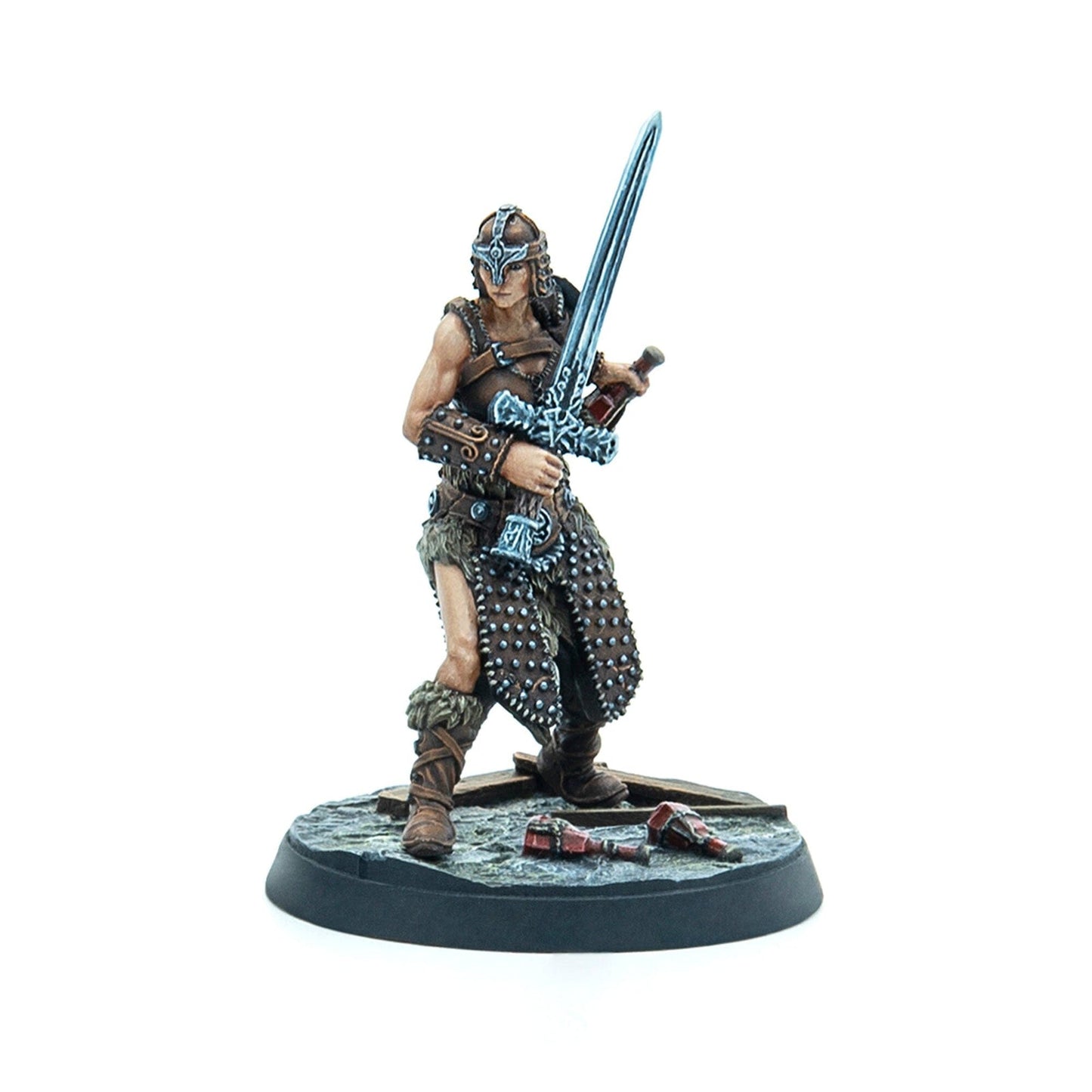 Miniature female warrior in fur and leather armor, helmeted, wielding a large ornate sword. Broken vials lie on the base.