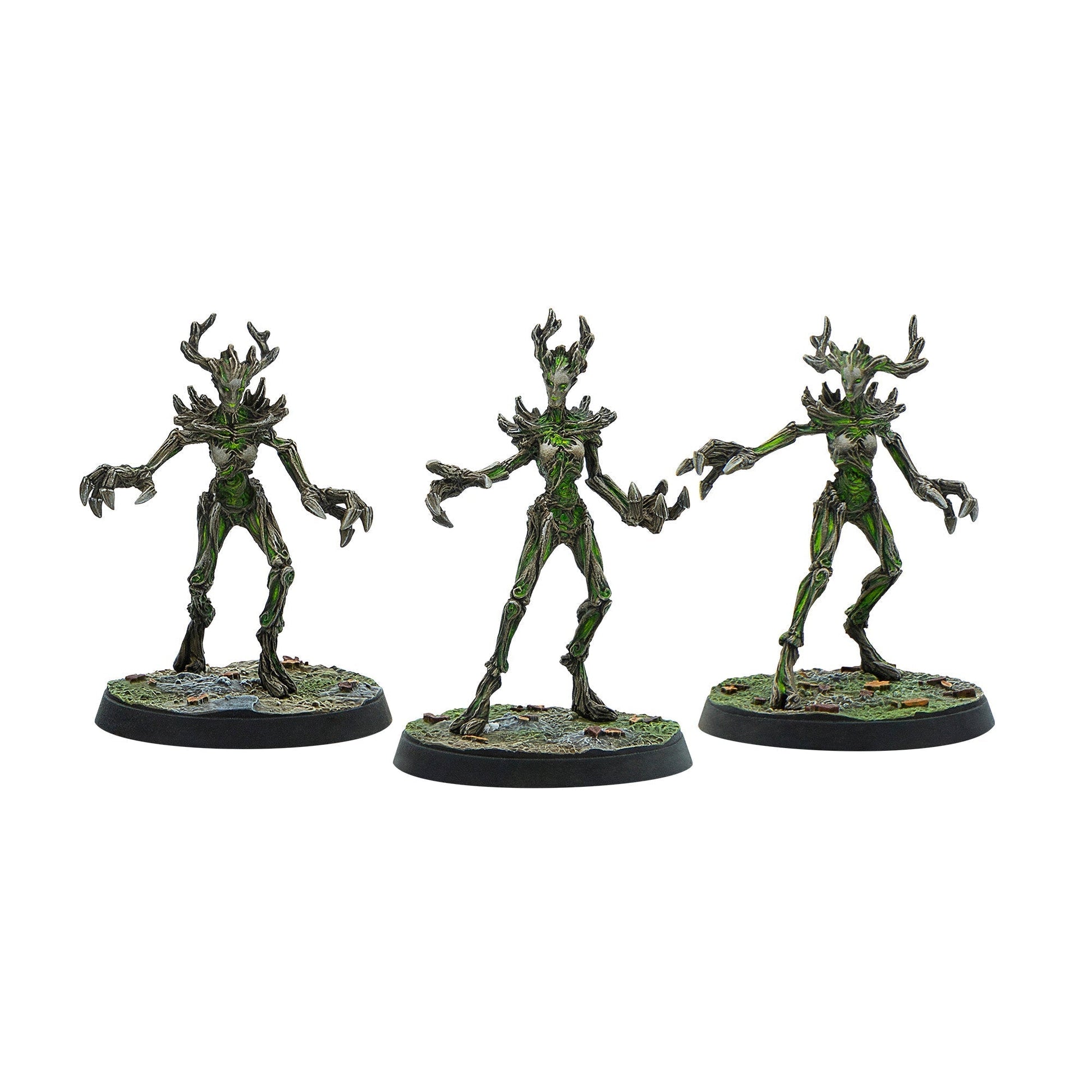 Three dark green and brown treemen miniatures with glowing green accents, antler-like heads, and sharp claws, posed for attack