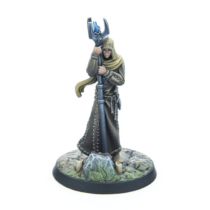 Fantasy miniature of a hooded, robed figure holding a staff with a blue crystal, standing on a rocky base