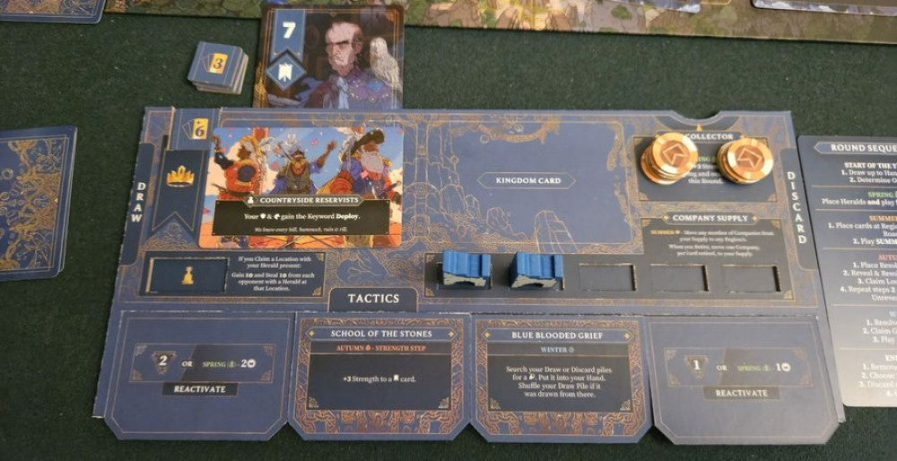 A blue and gold board game player dashboard showing cards, blue tactics tokens and gold resource chips