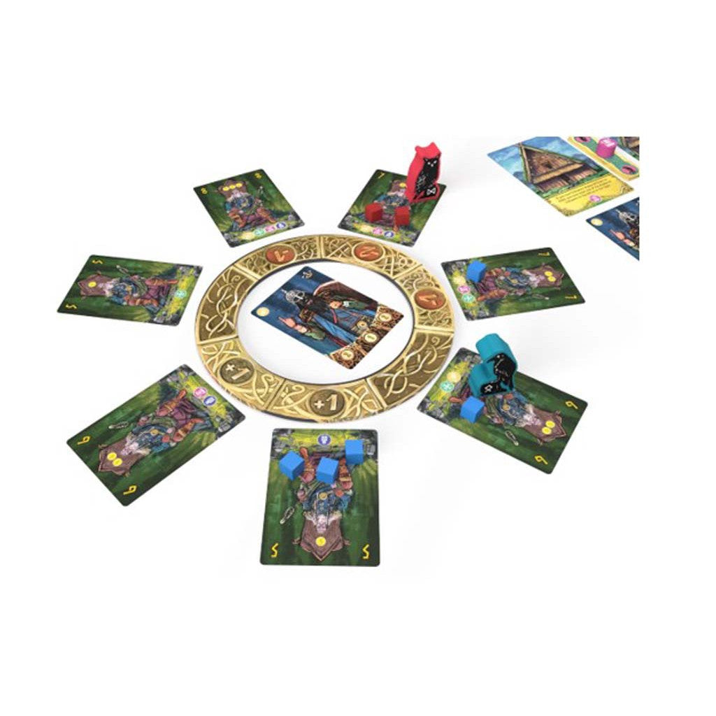 Tabletop Thingstead board game setup showing character cards arranged in a circle around a central ornate gold ring, with colored tokens and meeples