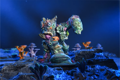Kings of War Coral Giant miniature, green, covered in colorful coral and seashells, on dark rocks