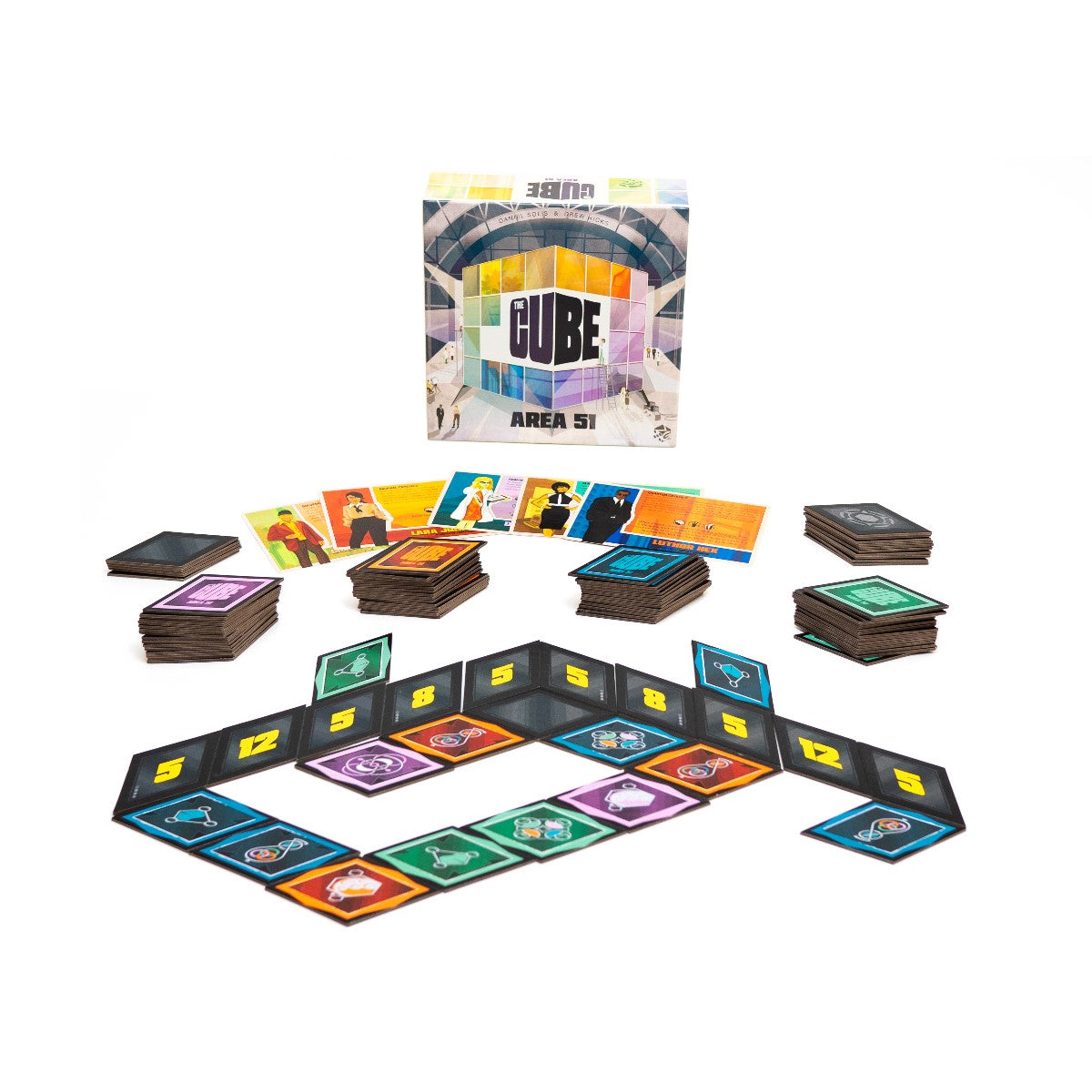 Complete setup of The Cube: Area 51 board game. Features the box, multiple card stacks and a path of colored symbol tiles.