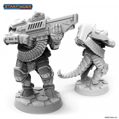 Two unpainted Starfinder Vesk Free Captain miniatures. One in armor aims a large rifle, the other is partially visible from behind