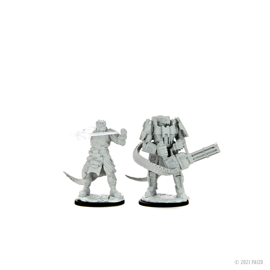Two grey unpainted miniatures: a reptilian warrior with a glowing energy blade, and a heavily armored figure with a minigun
