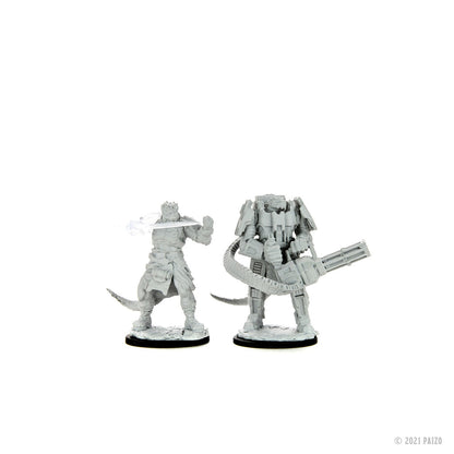 Two grey unpainted miniatures: a reptilian warrior with a glowing energy blade, and a heavily armored figure with a minigun