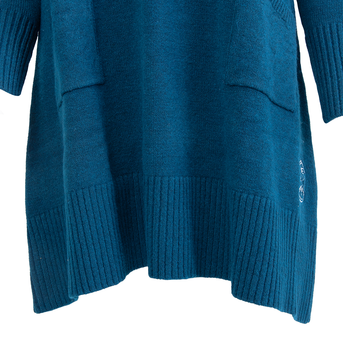A teal knitted sweater featuring ribbed cuffs and hem, two front pockets, and white embroidered smiley faces on the lower right