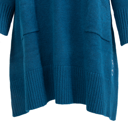 A teal knitted sweater featuring ribbed cuffs and hem, two front pockets, and white embroidered smiley faces on the lower right