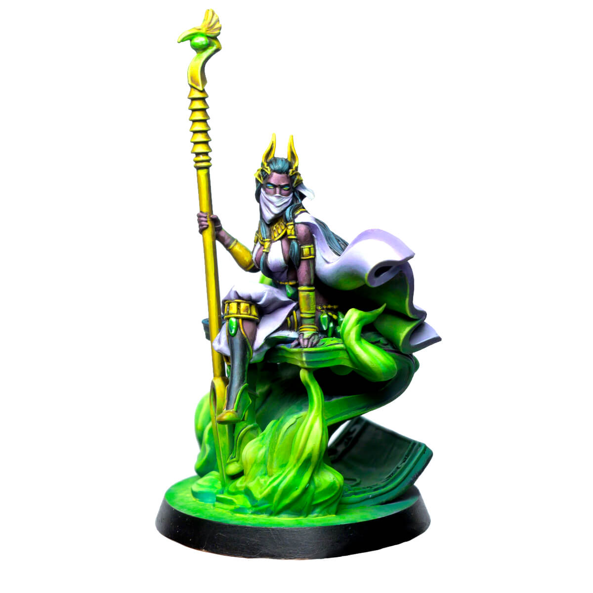 Fantasy miniature: A veiled, dark-skinned woman with golden horns sits on a glowing green base, holding a tall staff.