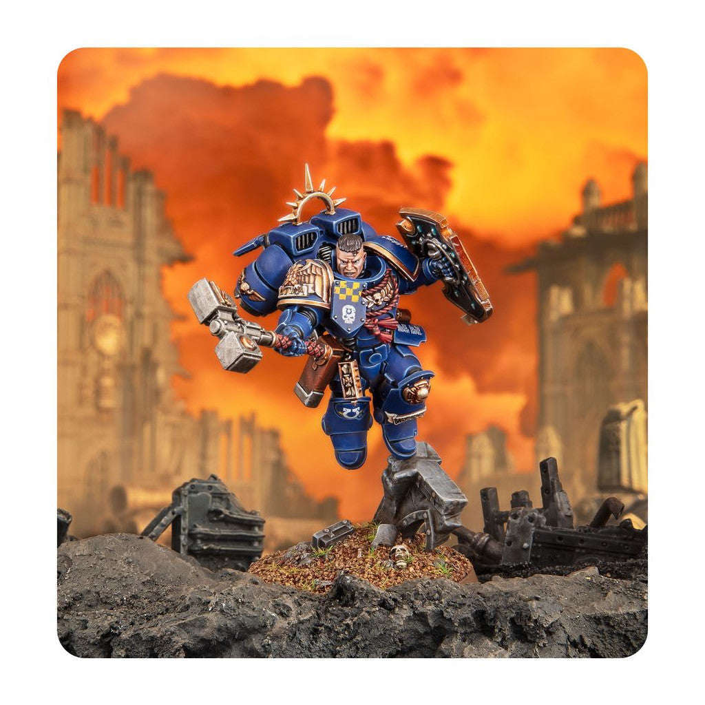 Blue Space Marine miniature with hammer and shield leaping over ruins under an orange sky
