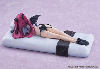 Anime figurine of a girl with long pink hair and black devil wings and horns lying on a white surface