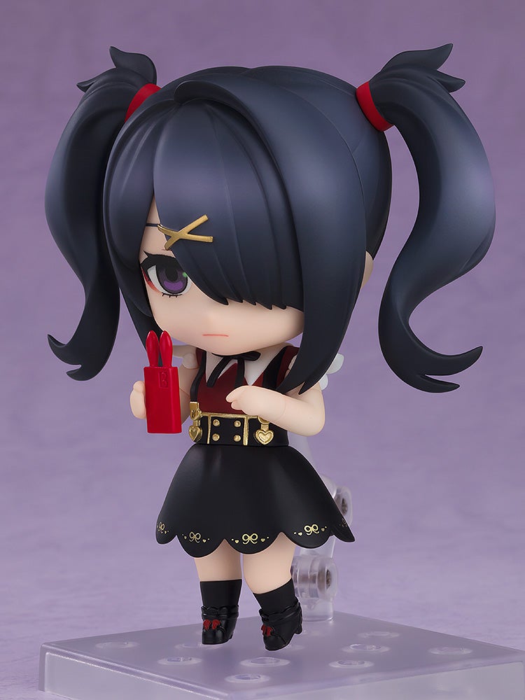 A Nendoroid figure of a dark-haired girl with pigtails in a black dress, holding a red bunny-eared object