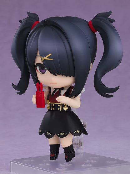 A Nendoroid figure of a dark-haired girl with pigtails in a black dress, holding a red bunny-eared object