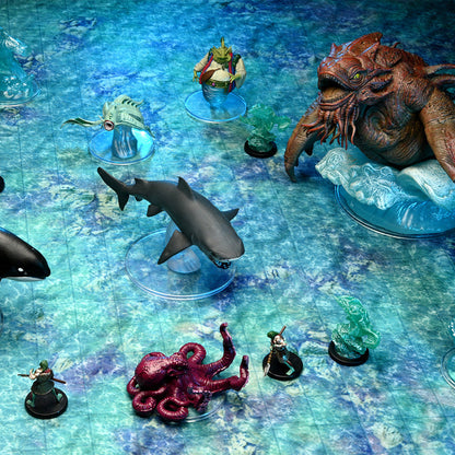 Tabletop miniatures: a large red kraken, shark, octopus, and smaller heroes on a vibrant blue-green ocean game mat