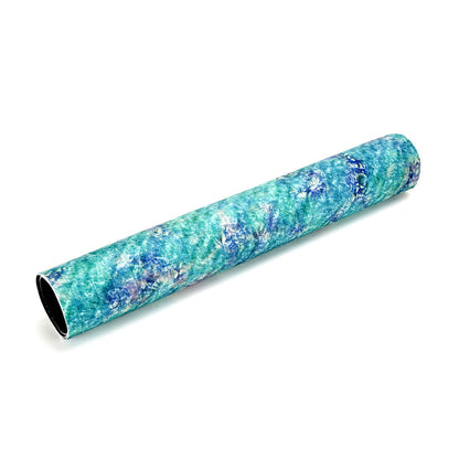 A roll of game mat with an abstract blue and green marbled pattern, on a white background
