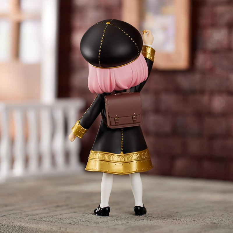 Anya Forger figure wearing black school uniform hat and backpack viewed from the back