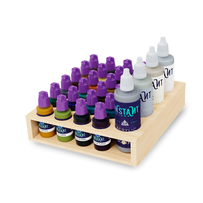 Assorted Instant Colors acrylic paint bottles with purple and white caps, neatly organized on a tiered wooden stand.