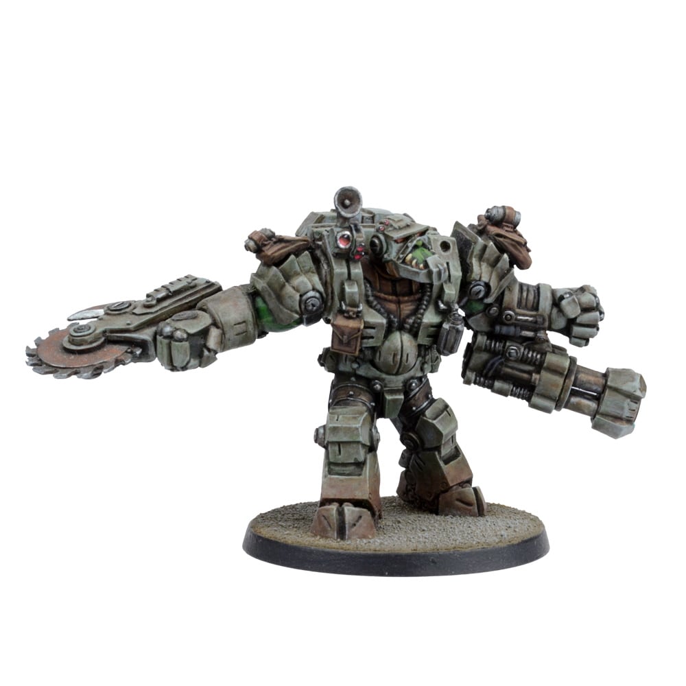 A heavily armored Ork miniature with a buzzsaw on one arm and a large multi-barreled cannon on the other