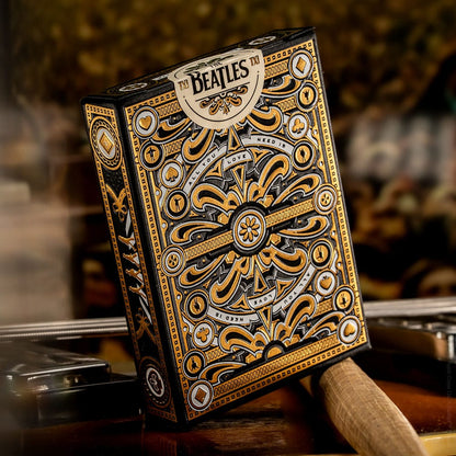 A black and gold ornate playing card tuck box featuring The Beatles logo and "All You Need Is Love"