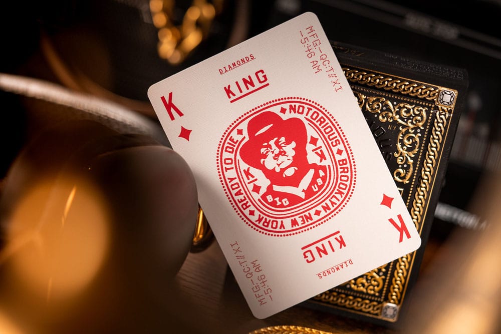 Custom King of Diamonds playing card with a red Notorious B.I.G. graphic, resting on a gilded black deck box