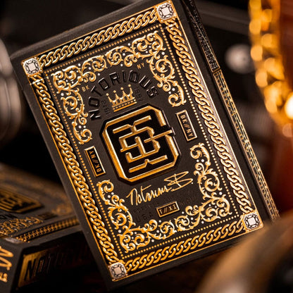 Black playing card box with ornate gold foil design, embossed chains and "Notorious" text