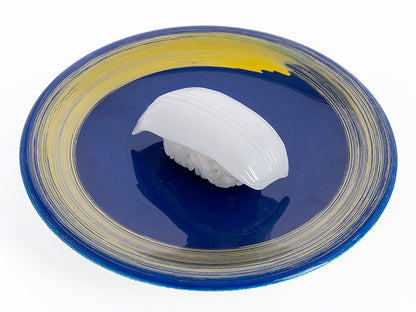 White squid nigiri sushi on a blue plate with yellow brushstroke patterns