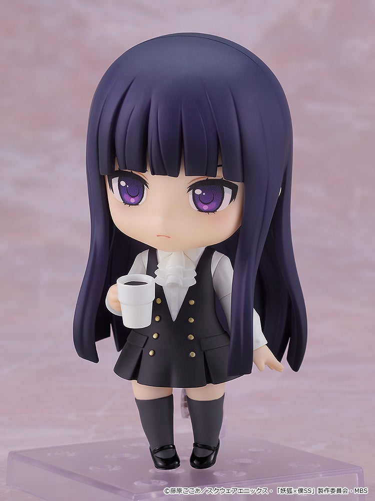 Chibi anime figure with long dark purple hair, wearing a black vest and skirt, holds a white coffee cup.