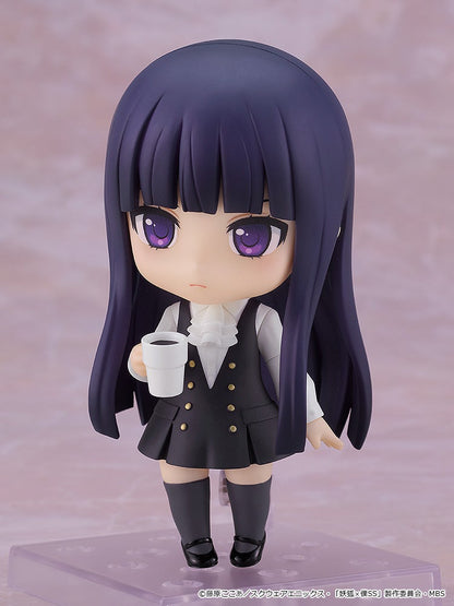 Chibi anime figure with long dark purple hair, wearing a black vest and skirt, holds a white coffee cup.