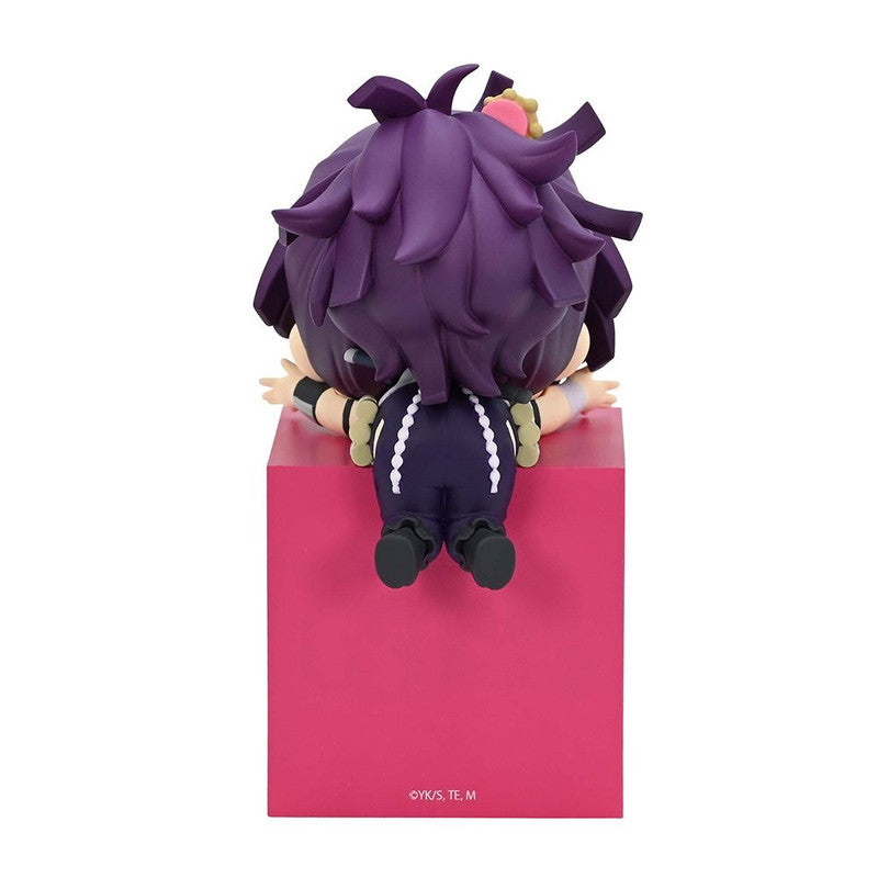 Chibi anime figure with purple hair and striped pants sits on a pink block facing away